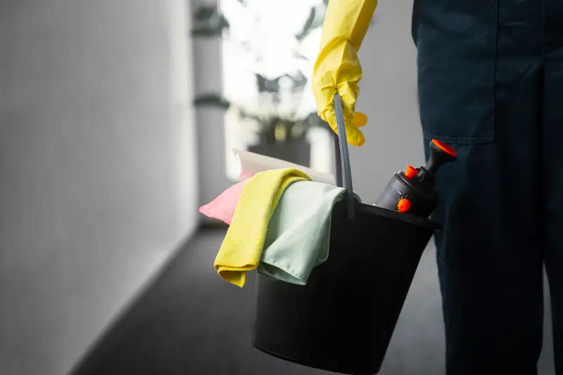 Professionelle Reinigungskraft mit Reinigungsutensilien im Einsatz